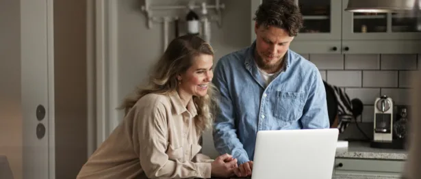 Man and woman in a kitchen working together on a laptop