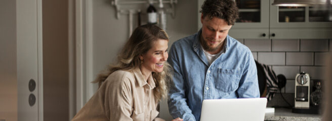 Man and woman in a kitchen working together on a laptop