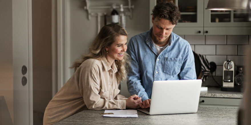 Man and woman in a kitchen working together on a laptop