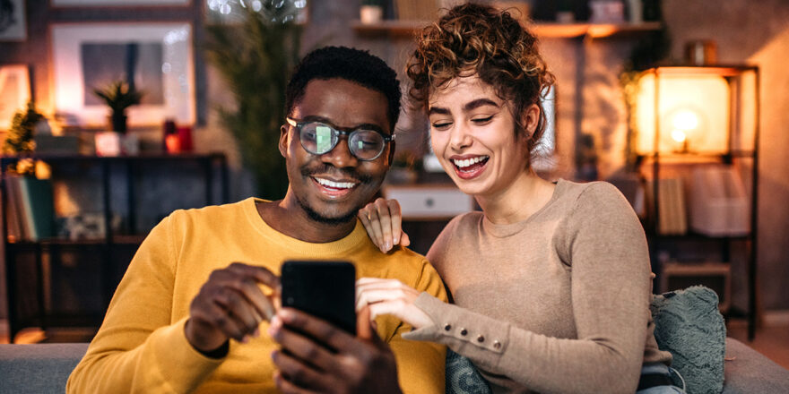 Young couple using smart phone to improve credit score