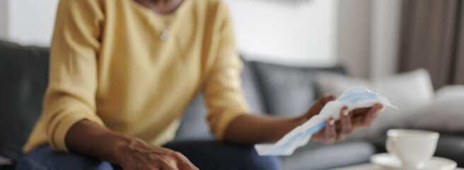 Close up of an adult woman filing her taxes, sitting in the living room