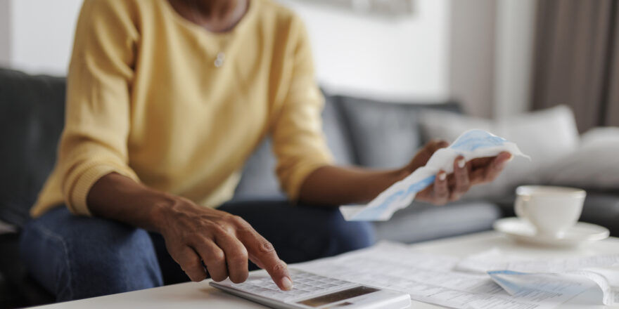 Close up of an adult woman filing her taxes, sitting in the living room