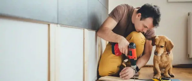 Man doing home improvements with his dog - Upstart Personal Loans