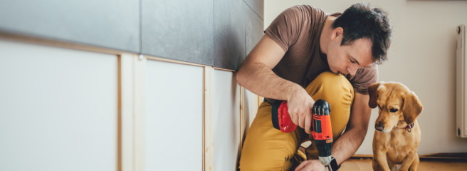 Man doing home improvements with his dog - Upstart Personal Loans