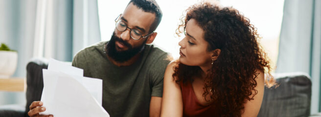 A man and woman read papers to learn about an emergency fund.