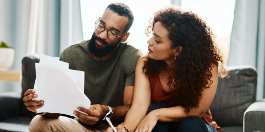 A man and woman read papers to learn about an emergency fund.