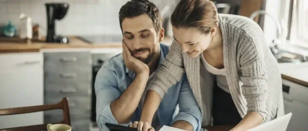 Couple looking at calculator - Upstart Personal Loans