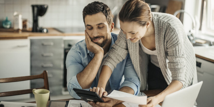 Couple looking at calculator - Upstart Personal Loans