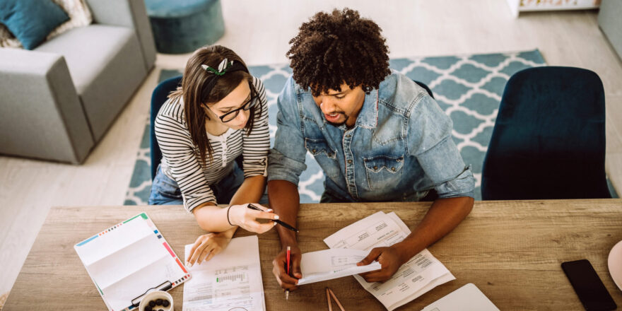 2 People reviewing bills at a table - Upstart Personal Loans