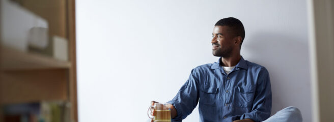 Man practicing self care with tea and a book