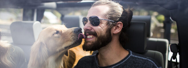 Man in a car getting licked by his dog - Upstart Personal Loans