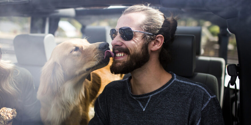 Man in a car getting licked by his dog - Upstart Personal Loans