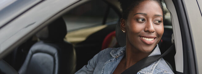 Portrait of young afro woman driving a car