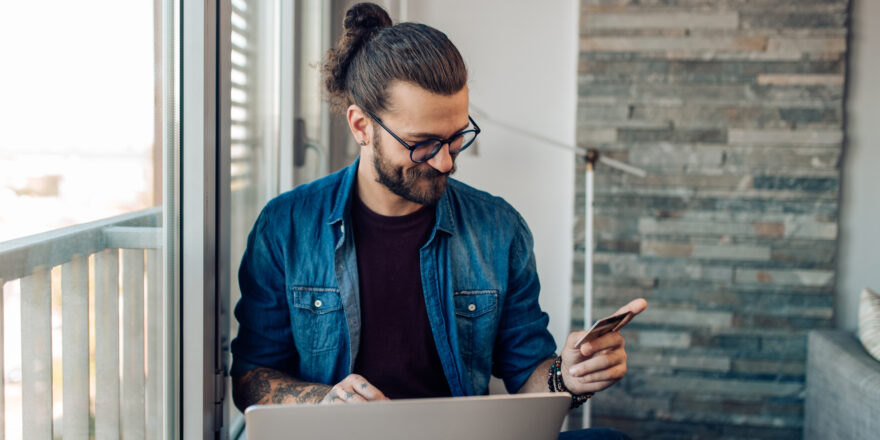 A man sits at his computer and calculates the cost of credit