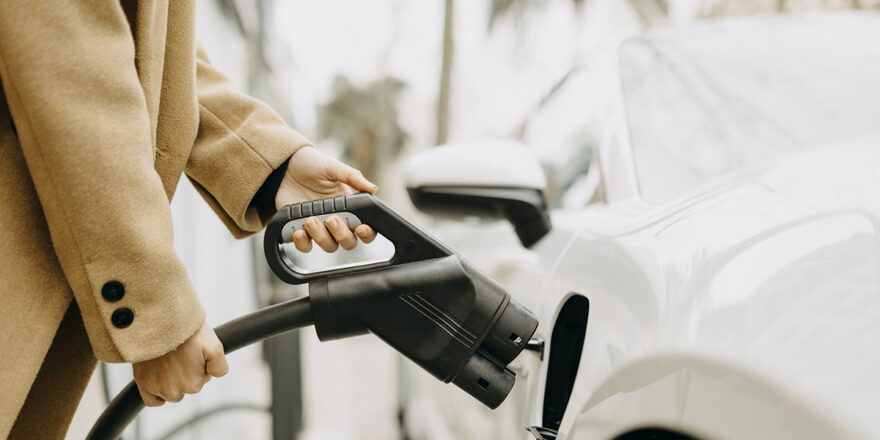 Person in coat putting fuel into their car
