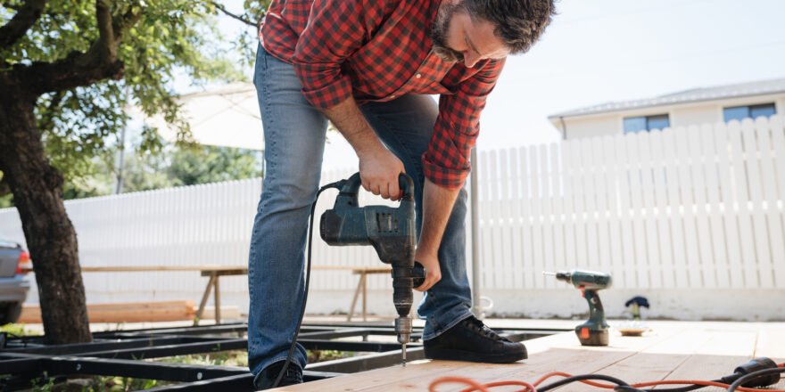 A man builds a deck using financing from a home improvement loan