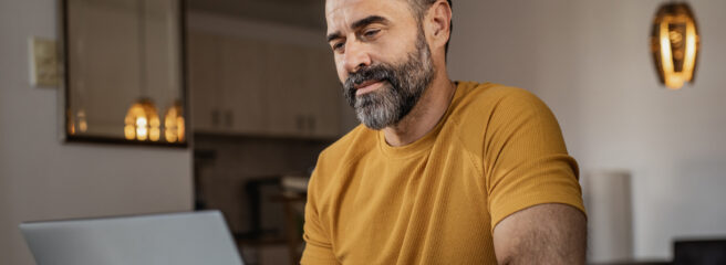 Man sits at computer and researches ways to financially prepare for inflation