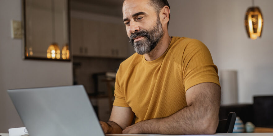 Man sits at computer and researches ways to financially prepare for inflation