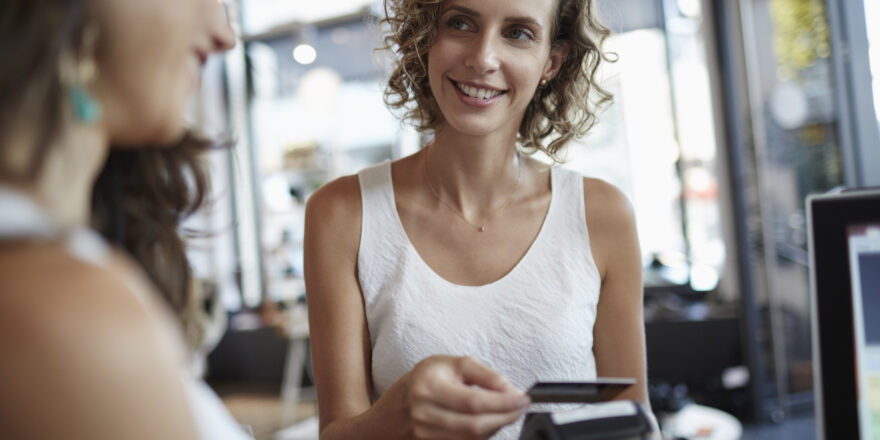 A woman uses a credit card to make a purchase in a retail store