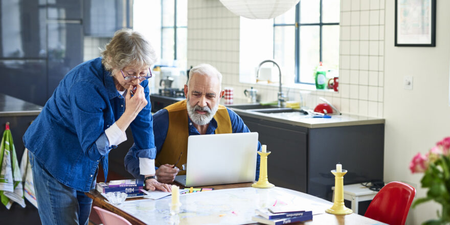 A couple researches the pros and cons of variable and fixed-rate loans using their laptop