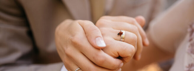 Married couple holds hands for photographer