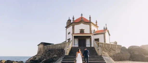 A newly married couple climbs the stairs outside of a destination wedding venue