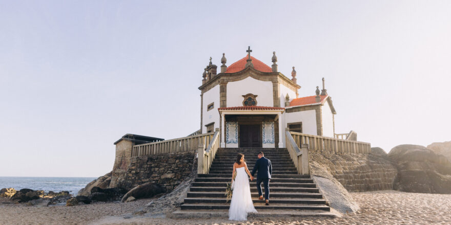 A newly married couple climbs the stairs outside of a destination wedding venue