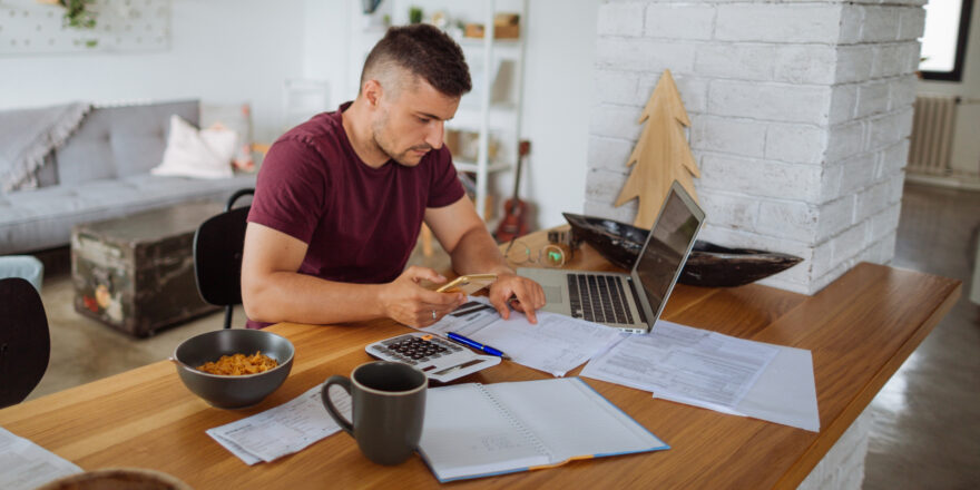 A person uses a computer to determine why their credit score dropped