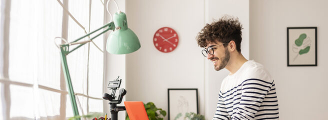 Young man using a laptop to research what a credit report is.