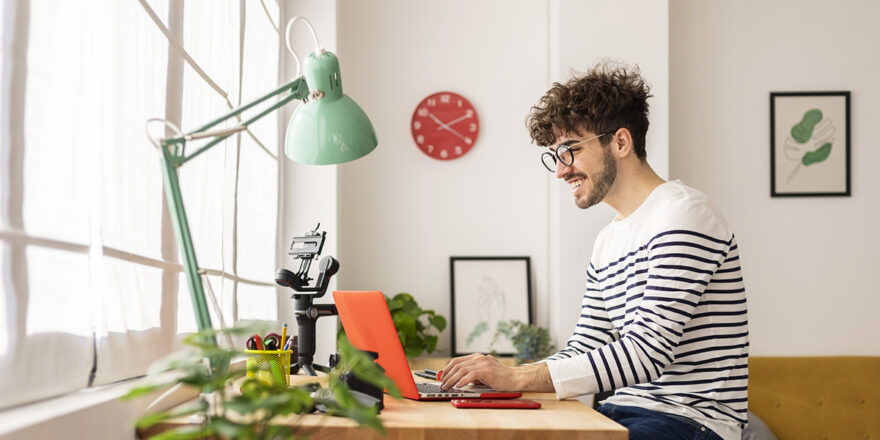 Young man using a laptop to research what a credit report is.