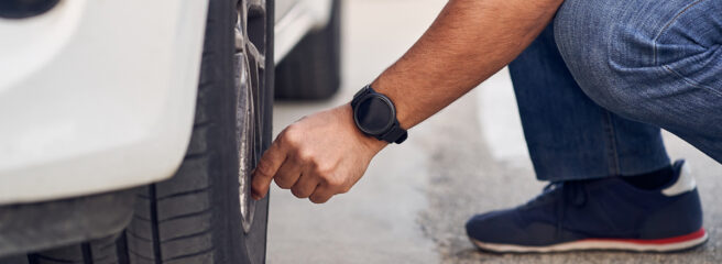 Man checking car tires to check tire pressure