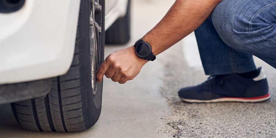 Man checking car tires to check tire pressure