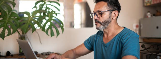 Older man on laptop learning about small loan