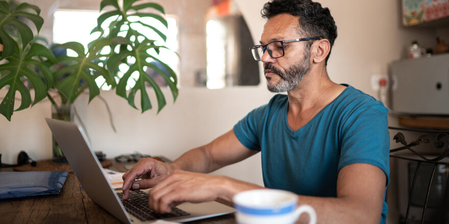 Older man on laptop learning about small loan