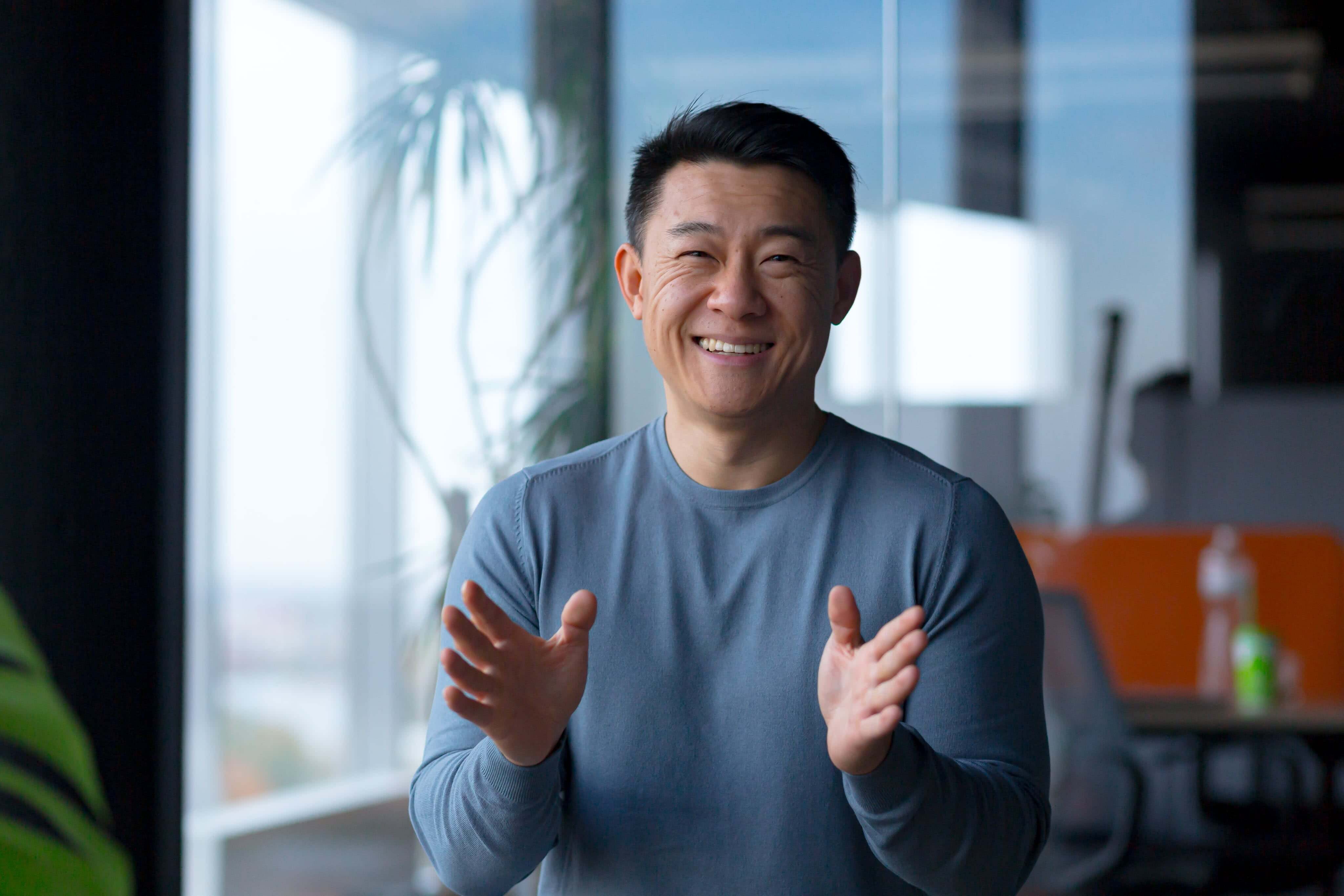 A smiling man in a blue shirt is happy about a personal loan for bad credit