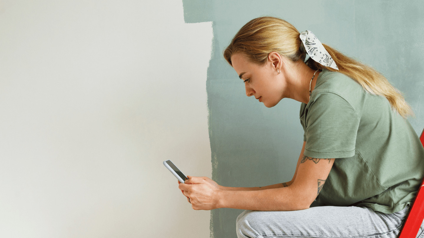 Young woman sitting and looking at phone about personal loans for bad credit