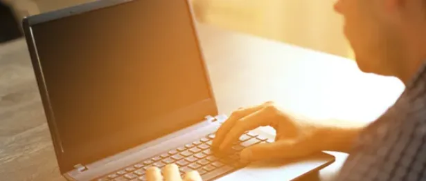 Man on his laptop in sunlight - Upstart Personal Loans