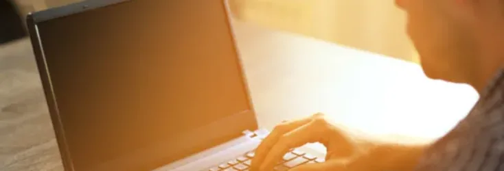 Man on his laptop in sunlight - Upstart Personal Loans