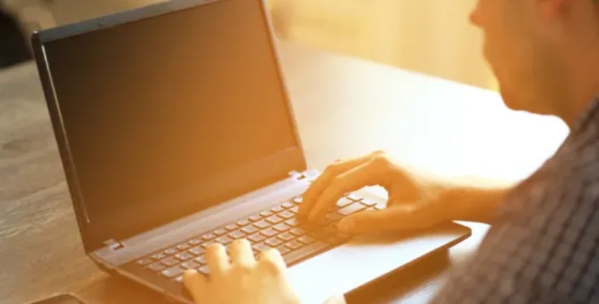 Man on his laptop in sunlight - Upstart Personal Loans