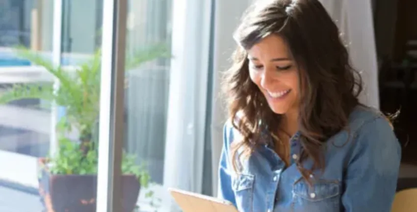 Woman using a tablet smiling - Upstart Personal Loans