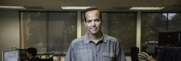 Man in collared shirt in an office - Upstart Personal Loans